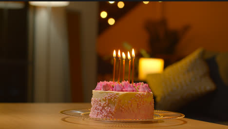 Nahaufnahme-Eines-Partykuchens-Zum-Geburtstag,-Dekoriert-Mit-Zuckerguss-Und-Kerzen-Auf-Dem-Tisch-Zu-Hause